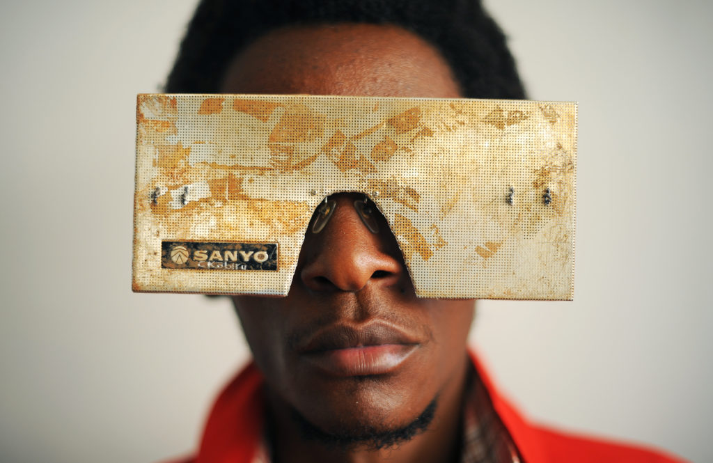 Kenyan artist Cyrus Kabiru poses with an artwork resembling sunglasses on February 1, 2012 in Nairobi