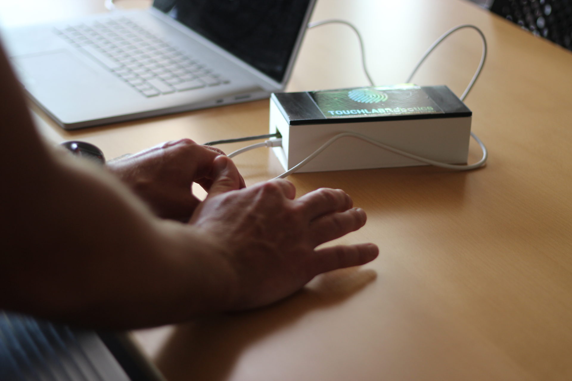 A close-up of Ray Holt’s hands demonstrating remote social haptics technology.
