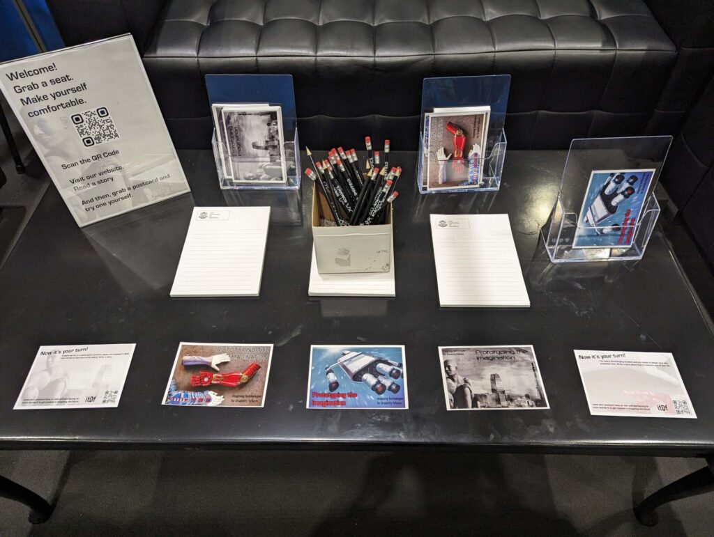 a black table laid out with a variety of postcards, pencils and writing pads